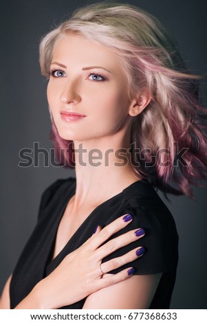 Beautiful blonde girl in black clothes. Purple hair. Informal appearance. Fashionable studio portrait. Model with clean skin
