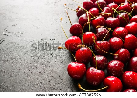 Wet fresh cherry on a black background close-up