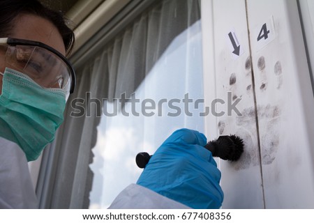 Forensic experts finds fingerprints on the window Royalty-Free Stock Photo #677408356