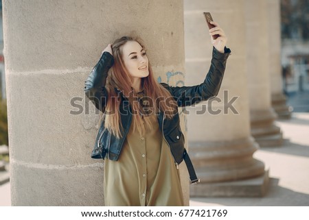 pretty girl in the summer city with smartphone near column