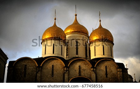 The golden domes of a Kremlin cathedral are radiant in the setting Moscow sun.