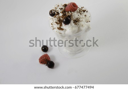 Delicious desert , a scoop of Vanilla ice cream covered with blue and red berries pressured with chocolate flavor on a clean white background