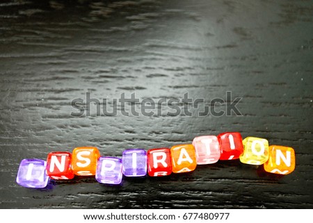 Close up inspiration. Word arrangement on the black background. Colorful alphabet cube make a colorful inspiration.
