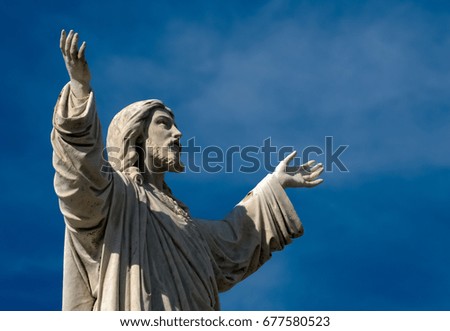 Jesus Christ statue against beautiful blue sky.