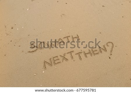 Handwriting  words "SO WATH NEXT THEN?" on sand of beach.