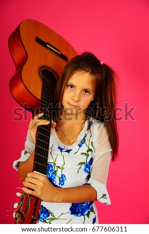 Girl with a guitar on a pink background