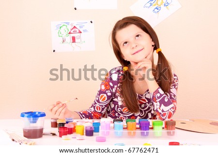 young and cute little girl painting a picture