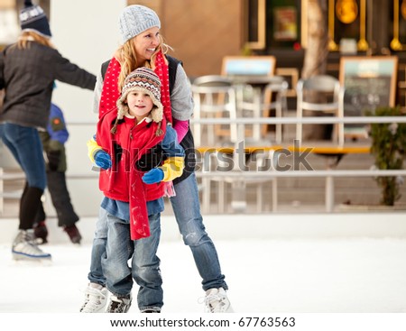 a mother helps her son learn to ice-skate