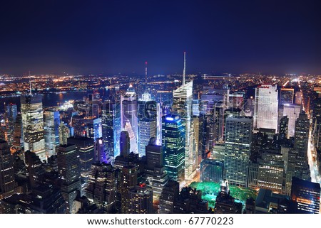 New York City Manhattan Times Square panorama aerial view at night with office building skyscrapers skyline illuminated by Hudson River.