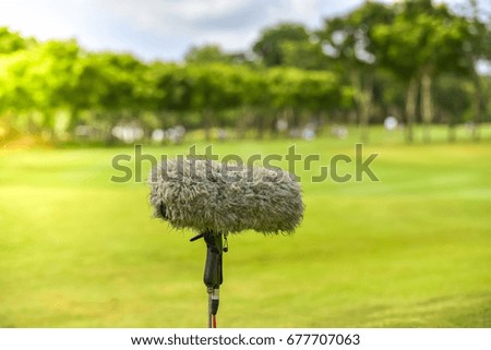 Professional microphone on green grass golf course.