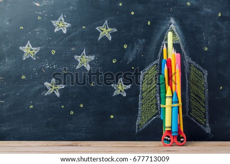 Back to school concept with rocket made from pencils over chalkboard background