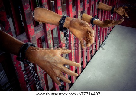 Human hand of ghost prisoner on steel lattice close up for Halloween background. Criminal hand show on steel lattice for help.