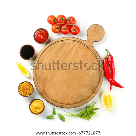 Composition with wooden board and different sauces on white background