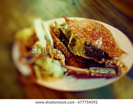 The burned sea crab is a delicious meal prepared on wooden table. The picture was blurred or selective focus.