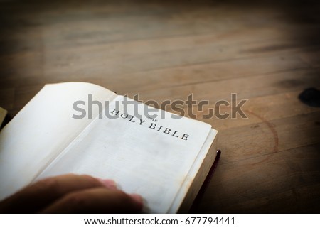 old open holy Bible with wooden table Royalty-Free Stock Photo #677794441