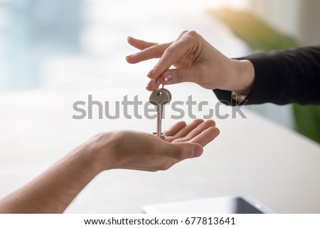 Real estate agent giving keys to apartment owner, buying selling property business. Close up of male hand taking house key from realtor. Mortgage for purchasing flat, getting access to own home Royalty-Free Stock Photo #677813641