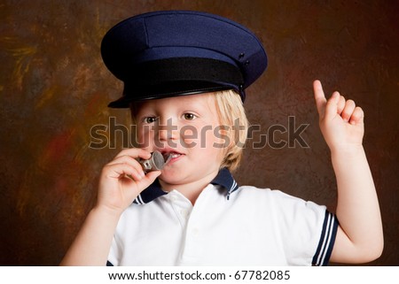 Young toddler boy with police whistle and hat
