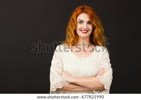 portrait of beautiful woman with red hair and green eyes posing in studio