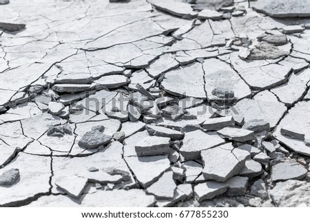 Cracked concrete texture background. Grey surface with cracks close up. A lot of pieces of splintered plaster. Abstract concept of split, dissent, disagreement, discord. Sunny day with shadows. Royalty-Free Stock Photo #677855230