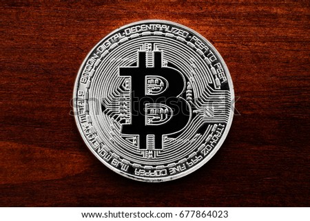 silver bitcoin on briwn wooden background 