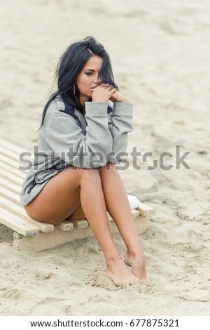 beautiful girl is conceived sitting on the beach