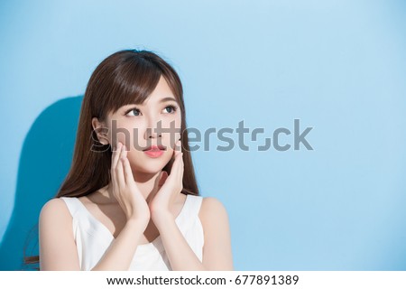 beauty woman touch her face on the blue background