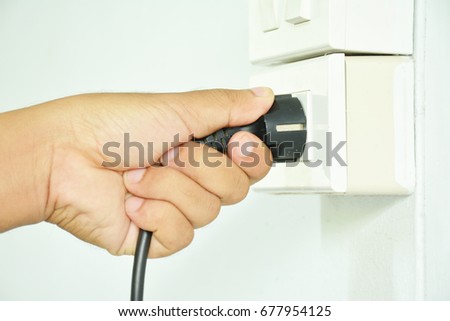 Human hand plugs electric plug