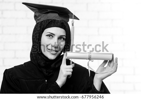 Happy graduate muslim student with diploma indoor.Black and white picture.