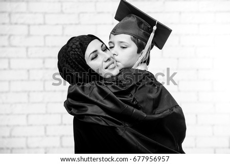 Arabic mother and son are preparing to graduation ceremony.Black and white picture.