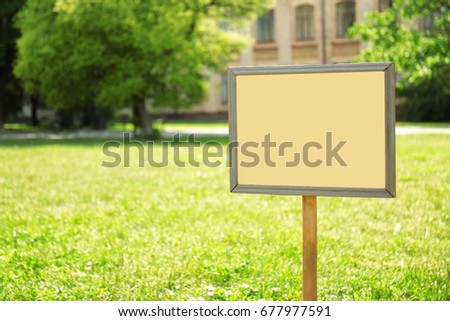 Blank board on green lawn in park