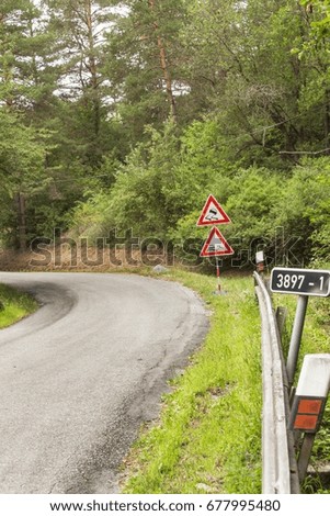 Road warning sign on slippery road. Spilled gravel on the road. Country road in the Czech Republic