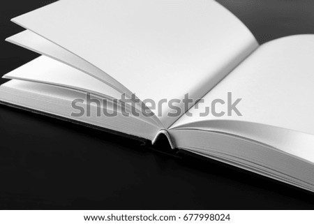 Open book with blank pages on black background