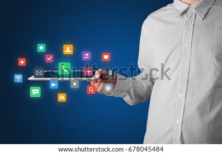 Casual businessman holding tablet with colorful applications 