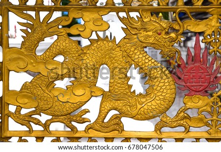 Gold dragon on the steel door in Thai temple.