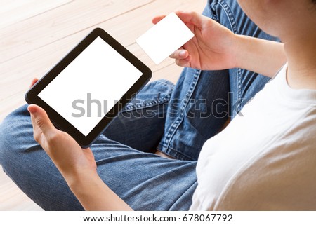 man holding credit card and using mobile tablet computer with blank white screen for online shopping - clipping path inside