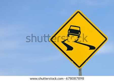 Yellow traffic sign "Slippery Road" on the sky background