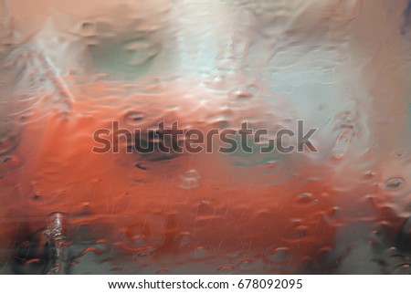 Abstract blurred image through the windshield of the car during rain