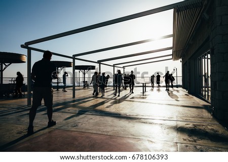 Silhouette of people walking on terrace at sunset