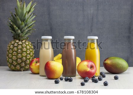 different bottles of juice with fresh fruits on wooden table