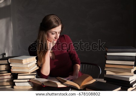 girl reading a book in the library is preparing for the exam