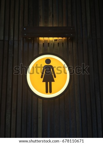 Toilet woman sign on orange background with light