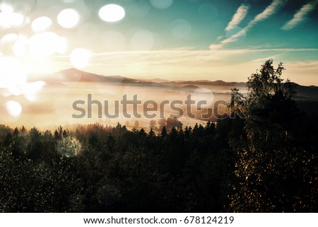 Film grain effect. Amazing  daybreak in Saxony Switzerland park. Sandstone peaks increased from foggy background