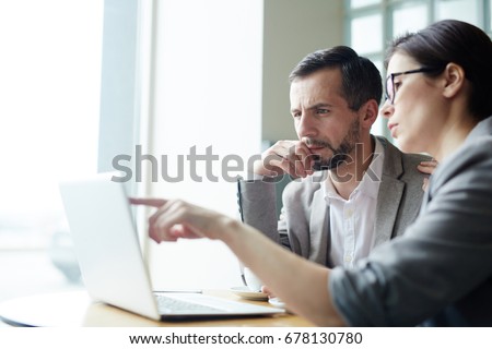 Two analysts discussing online data in front of laptop Royalty-Free Stock Photo #678130780