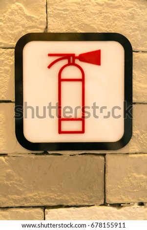 The Symbol of fire extinguisher on the brick