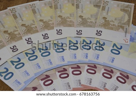 Euro banknotes spread out on a wooden table