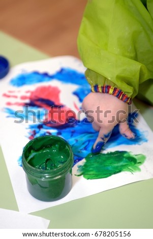 Imprint of watercolor paint on a child's hand on paper
