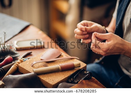 close up Man hands working with leather using crafting DIY tools