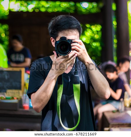 the man is taking a photo with DSLR camere. He is smart man.
