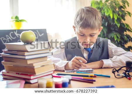 Back to school. Cute child sitting at the desk in the classroom. Boy is learning lessons. Concept for the first time in elementary school