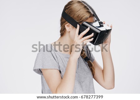 Beautiful young woman on white isolated background in virtual reality glasses.